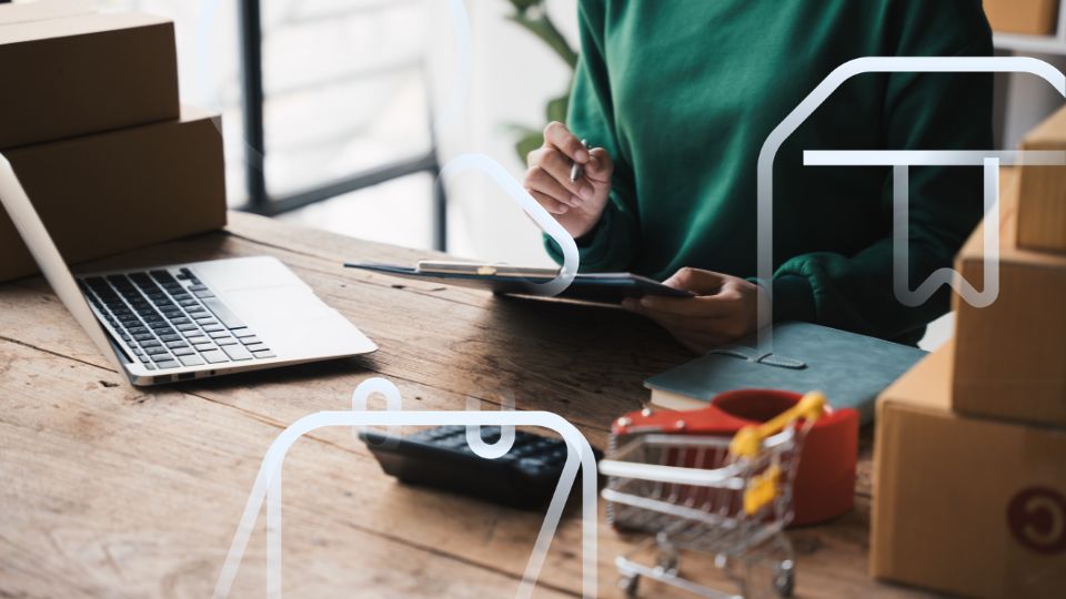 Pessoa consultando tablet com caixas ao redor, fazendo categoriza&ccedil;&atilde;o de produtos